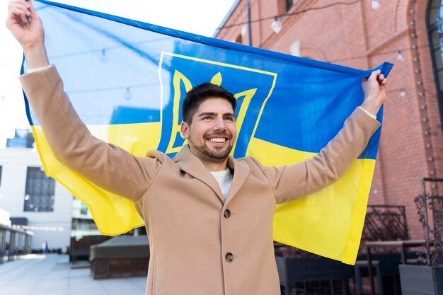 medium shot proud man holding ukrainian flag