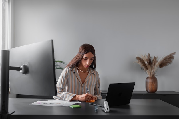 Foto gratuita modello queer a tiro medio che lavora con il laptop