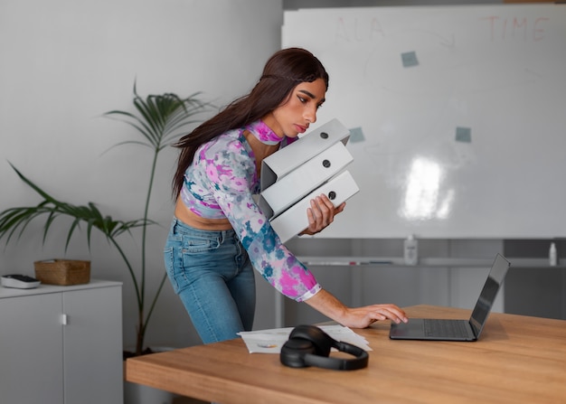 Medium shot queer model working with laptop