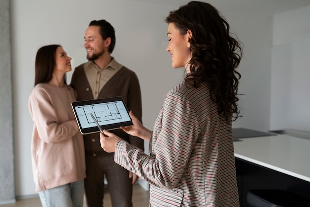 Medium shot real estate agent showing house