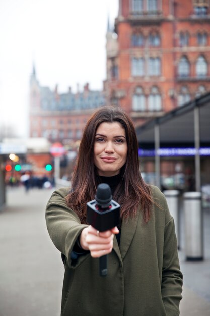 Medium shot reporter holding microphone