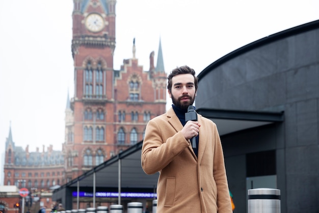 Medium shot reporter holding microphonee