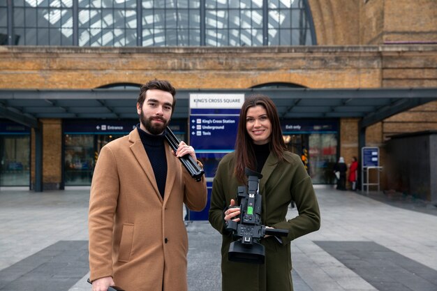 Medium shot reporters with equipment