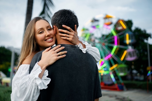 Medium shot romantic couple hugging outdoors