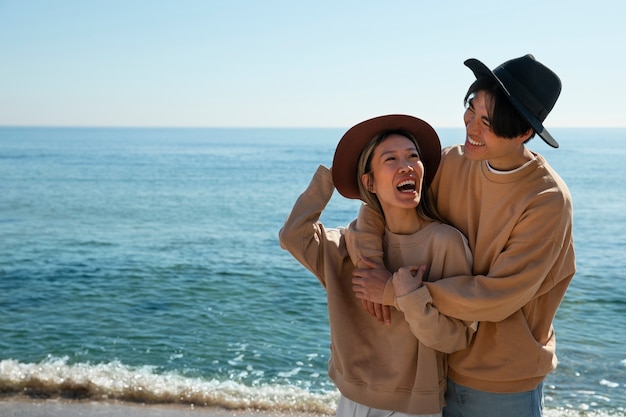 Coppia romantica di tiro medio in riva al mare