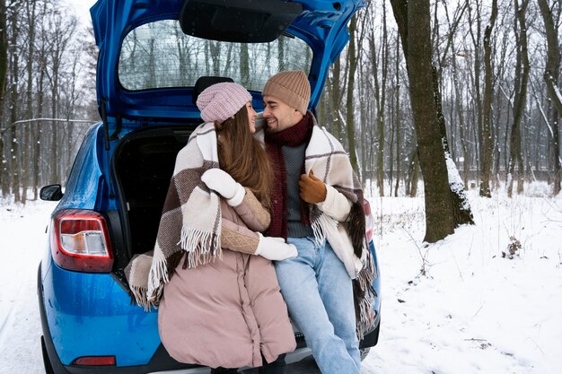 Medium shot romantic couple with car