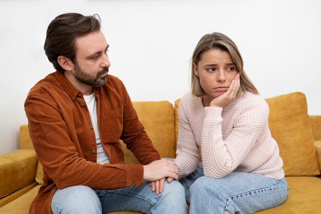 Medium shot sad couple on couch