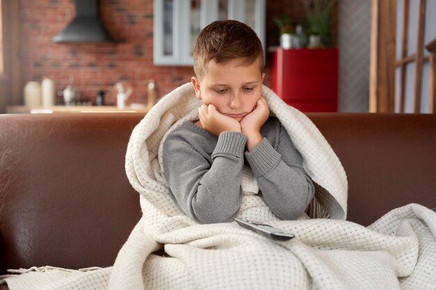 Medium shot sad kid sitting on couch