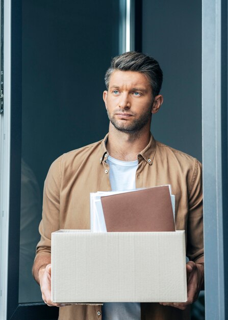 Free photo medium shot sad man holding box