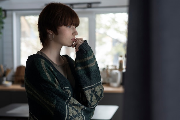Medium shot sad woman looking out the window