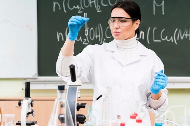 Foto gratuita scienziato del colpo medio che tiene il tubo del laboratorio