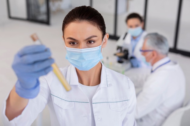 Free photo medium shot scientist holding tube