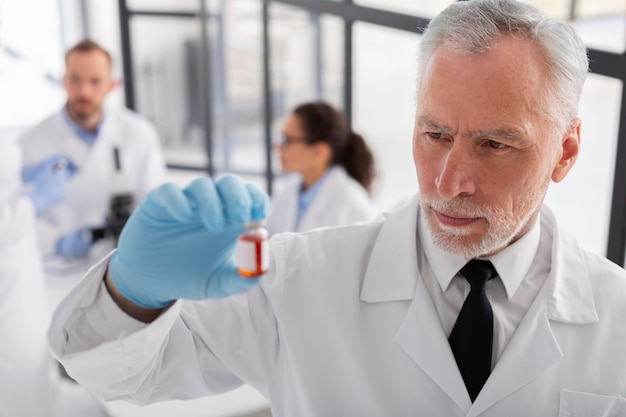 Free photo medium shot scientist holding vial