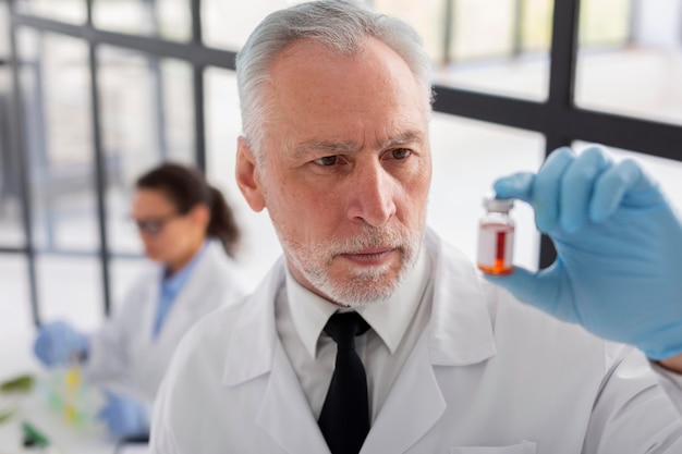 Free photo medium shot scientist holding vial