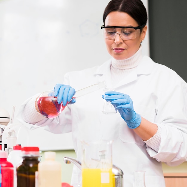 Medium shot scientist pouring solution