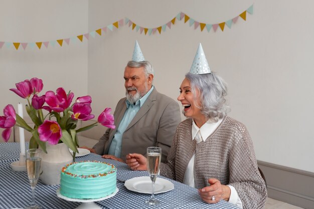 Medium shot senior couple celebrating with cake