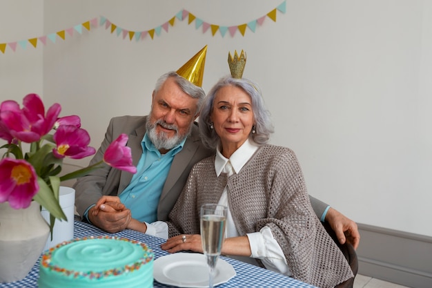 Medium shot senior couple celebrating with cake