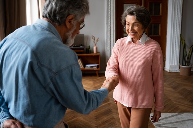 Coppia senior di tiro medio che balla al chiuso