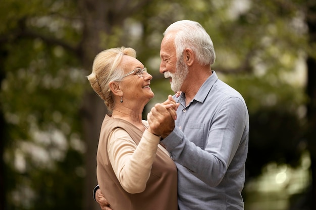 Free photo medium shot senior couple dancing outdoors