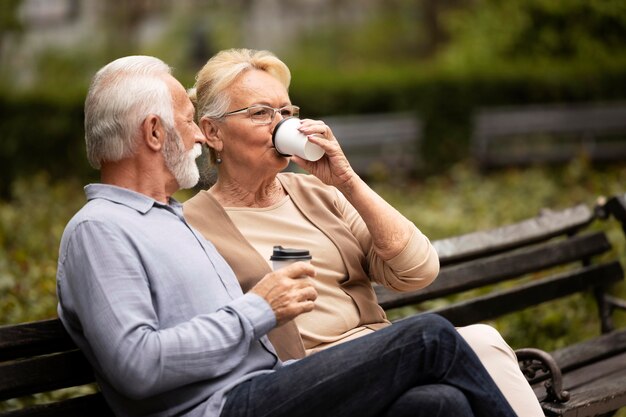 コーヒーを飲むミディアムショットの年配のカップル