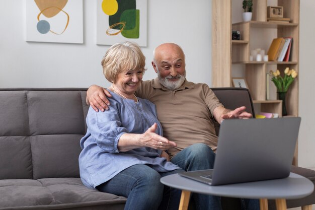 Medium shot senior couple looking at laptop