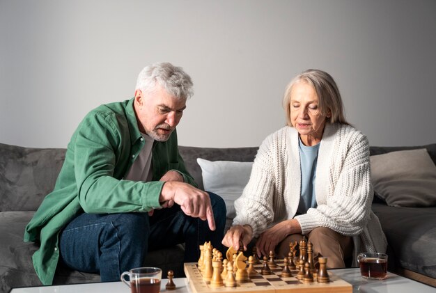 Medium shot senior couple playing chess