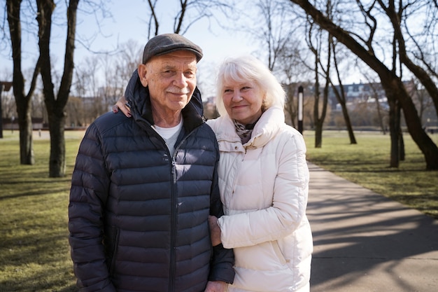 Medium shot senior couple walking together in park