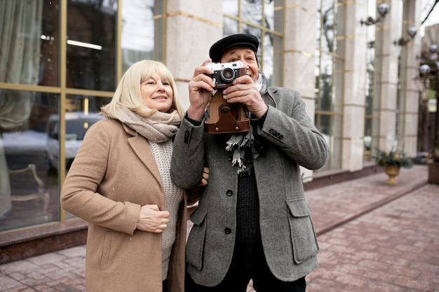 Средний снимок пожилой пары с фотоаппаратом