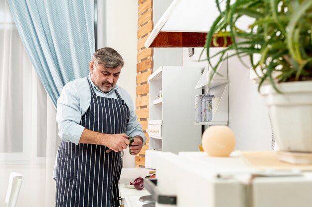 Medium shot senior man holding a knife