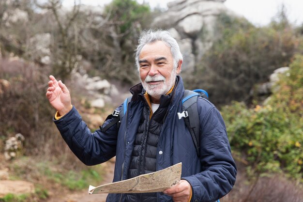 Medium shot senior man holding map