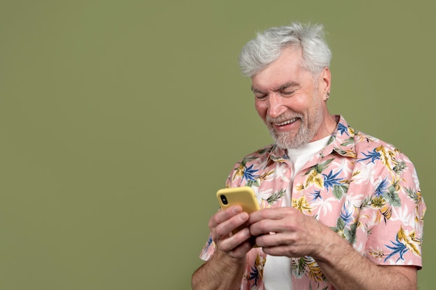 Free photo medium shot senior man holding smartphone