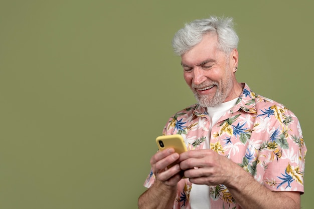 スマートフォンを持っているミディアムショットの年配の男性