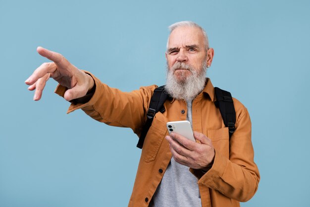 スマートフォンを持っているミディアムショットの年配の男性