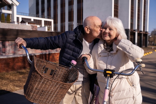 Medium shot senior man kissing woman on cheek