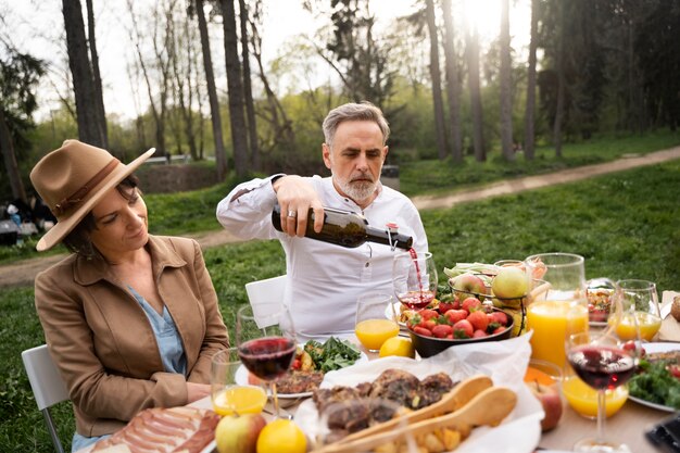 Medium shot senior man pouring wine