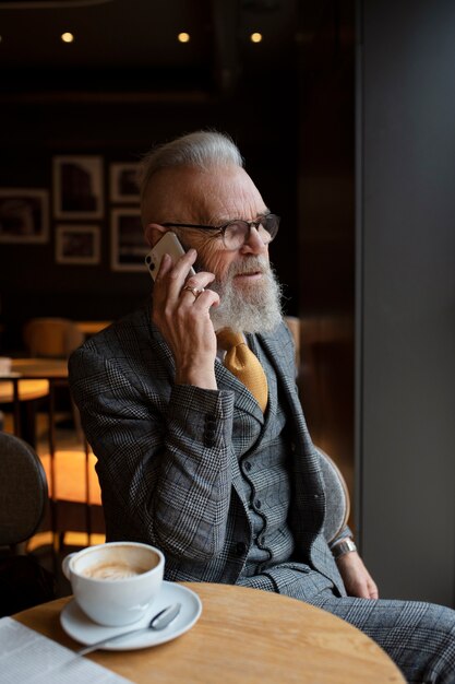 Free photo medium shot senior man sitting in cafe