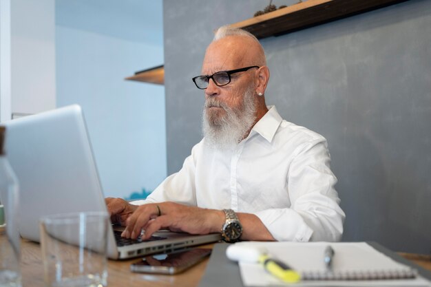 Medium shot senior man typing on keyboard