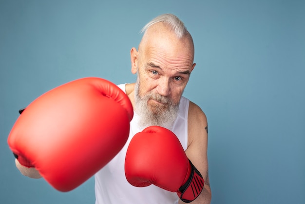 Medium shot senior man with boxing gloves