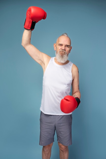 Medium shot senior man with boxing gloves