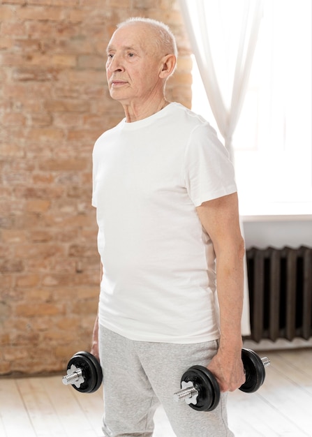 Free photo medium shot senior man with dumbbells