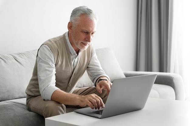 Medium shot senior man with laptop