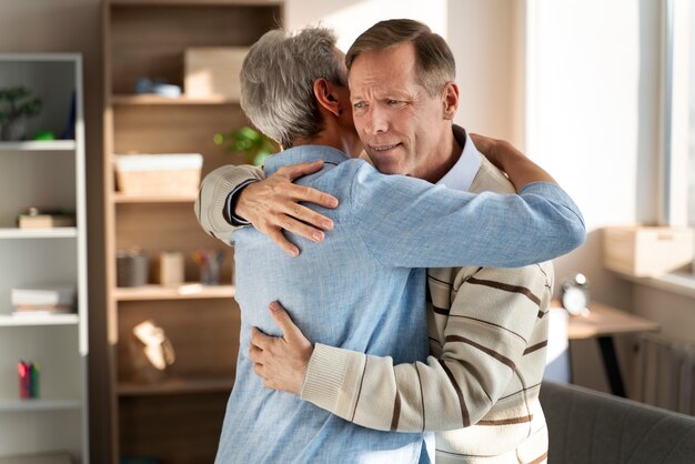Medium shot senior men hugging