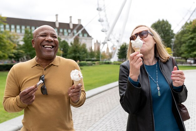 Пожилые люди среднего возраста едят мороженое