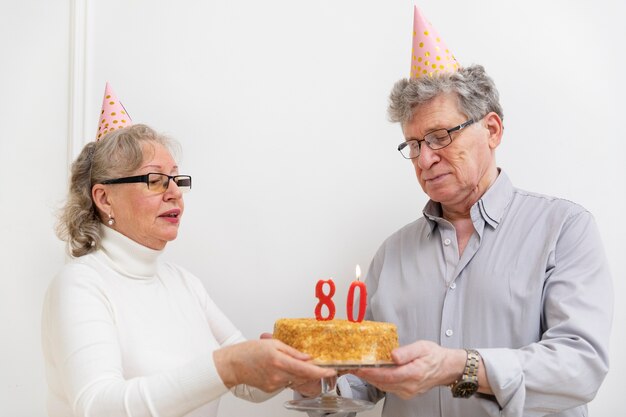 Medium shot senior people holding cake