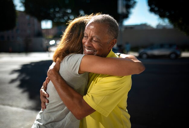 Medium shot senior people hugging outdoors