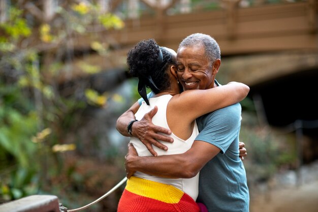 Medium shot senior people hugging outdoors