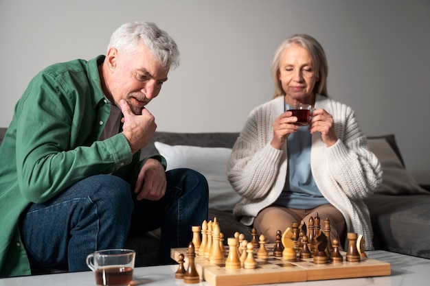 Medium shot senior people playing chess