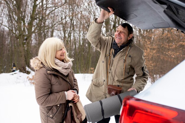 Free photo medium shot senior people with car