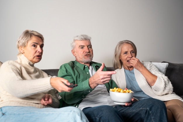 Persone anziane a tiro medio con popcorn