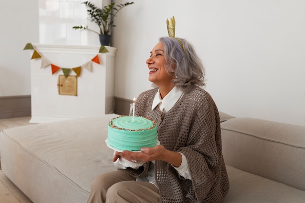 Medium shot senior woman celebrating with cake